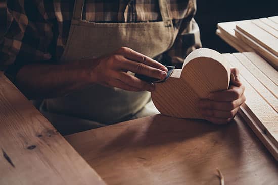 wood carver with a wooden heart