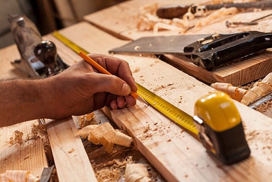 measuring wood with a tape