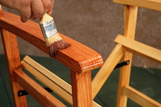 brushing varnish on a chair